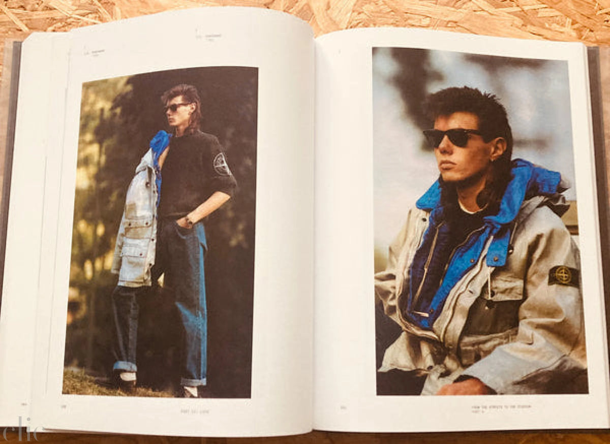 Open book showing two photos of a person wearing sunglasses and a jacket on a wooden surface.
