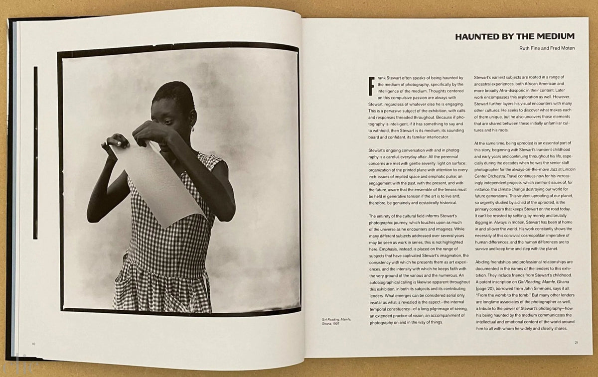 Open book with a black and white photograph of a person in a checkered dress on the left page and text on the right page.
