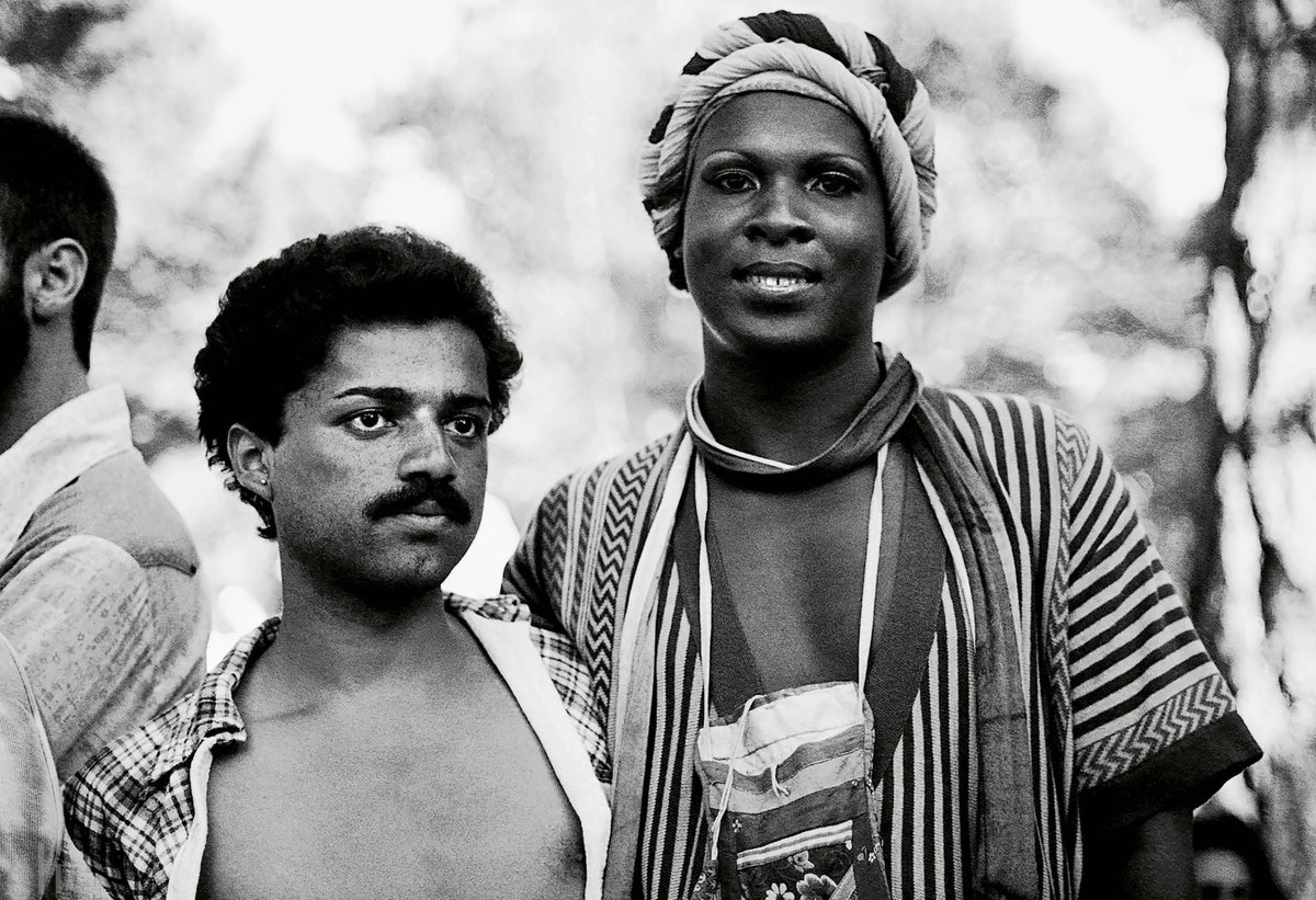 Black and white photograph of two people standing outdoors with a blurred background