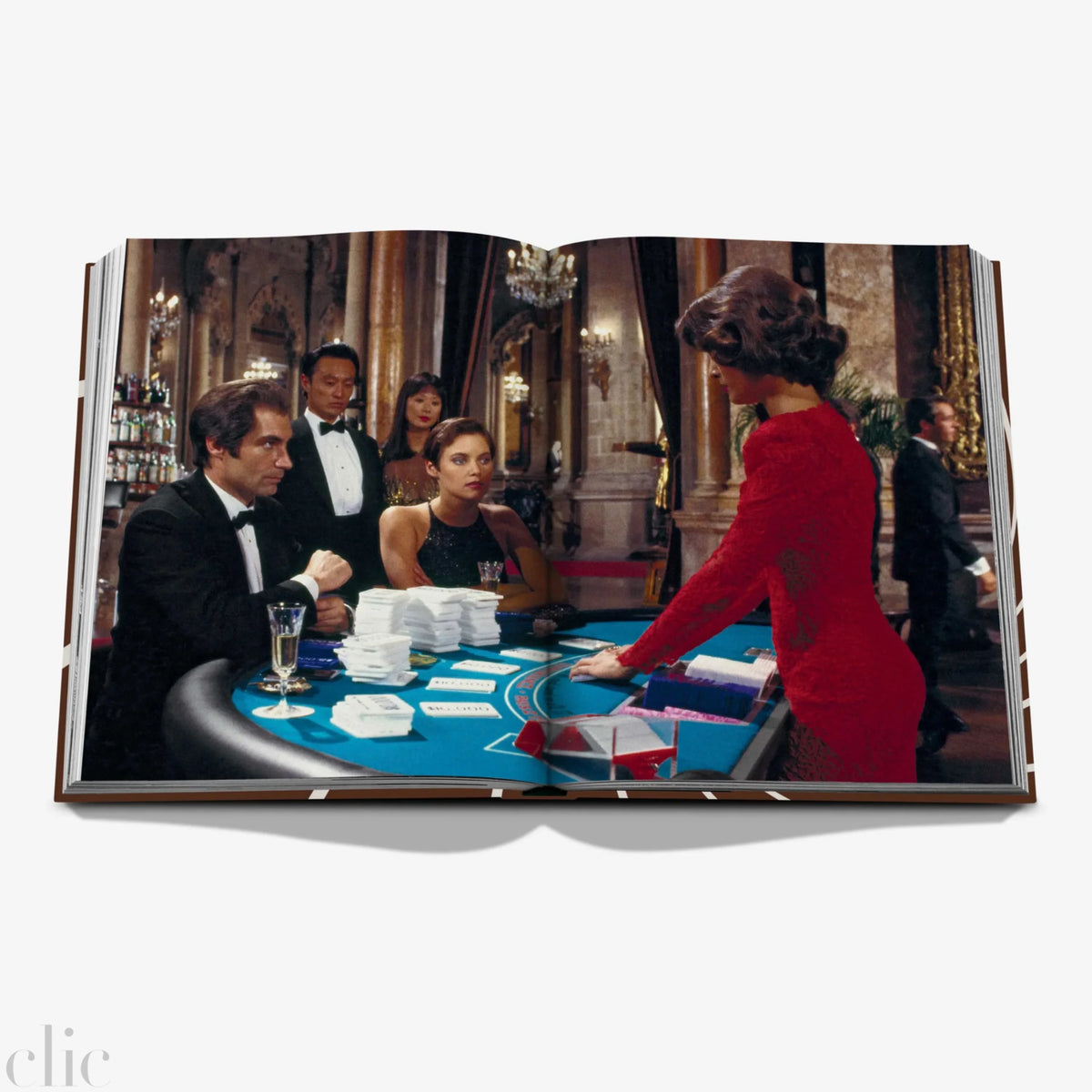 Open book showing a scene from a movie with people around a card table.